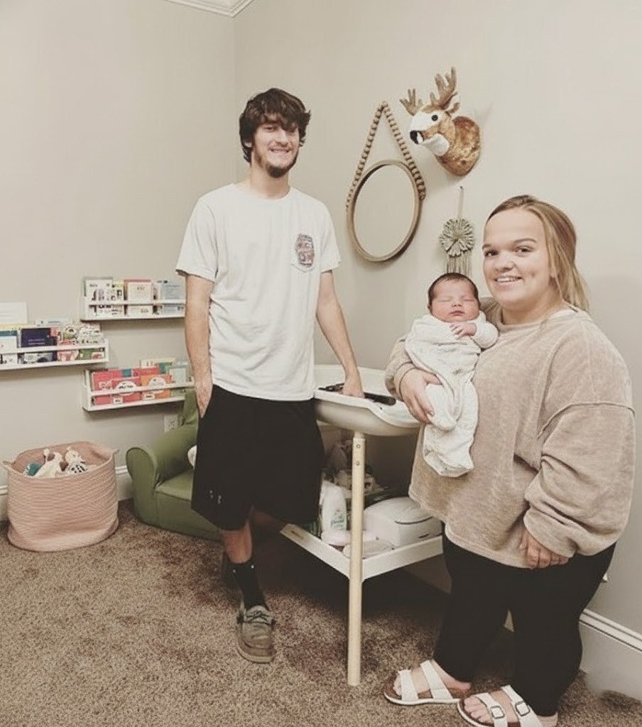 Liz Johnston holding newborn baby Coleman with Brice Bolden in the nursery
