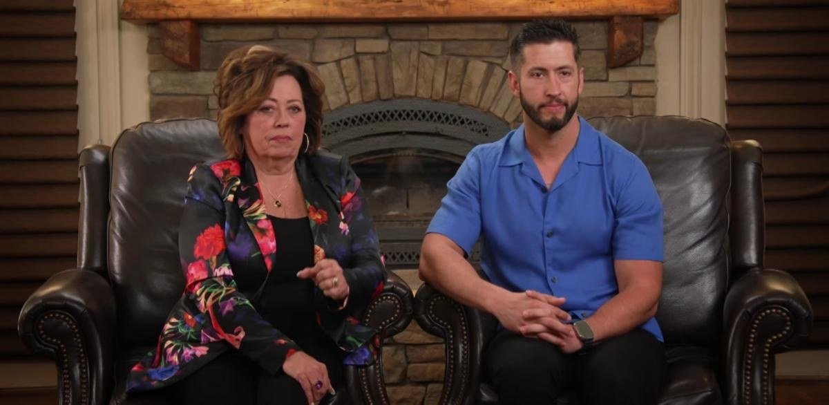Matt McAdams and his mother Kelly from I Love a Mama's Boy sitting in front of a fireplace