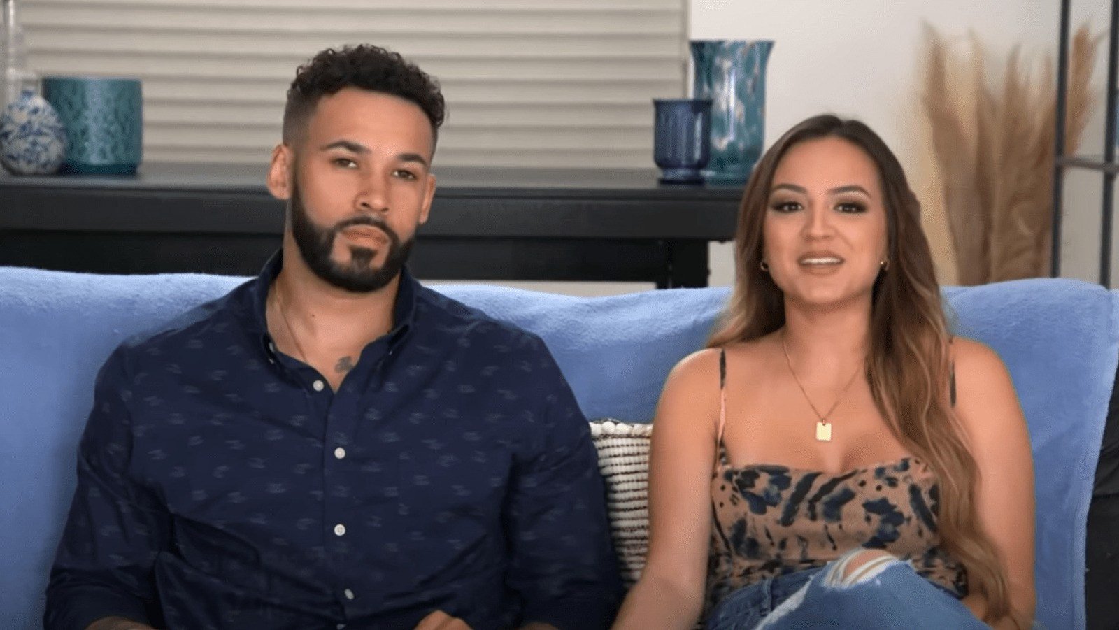 Tracy and Bryan from I Love a Mama's Boy sitting on a couch