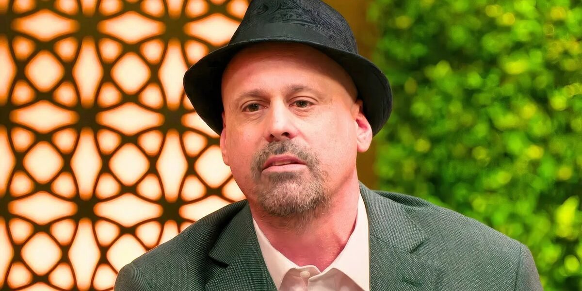 Gino Palazzolo in a black hat looking serious outdoors