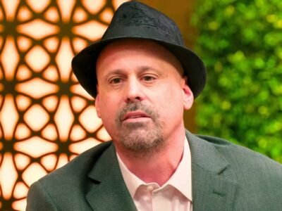 Gino Palazzolo in a black hat looking serious outdoors