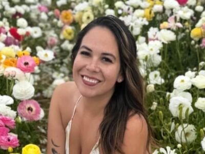 Liz Woods smiling with dark brunette hair among flowers