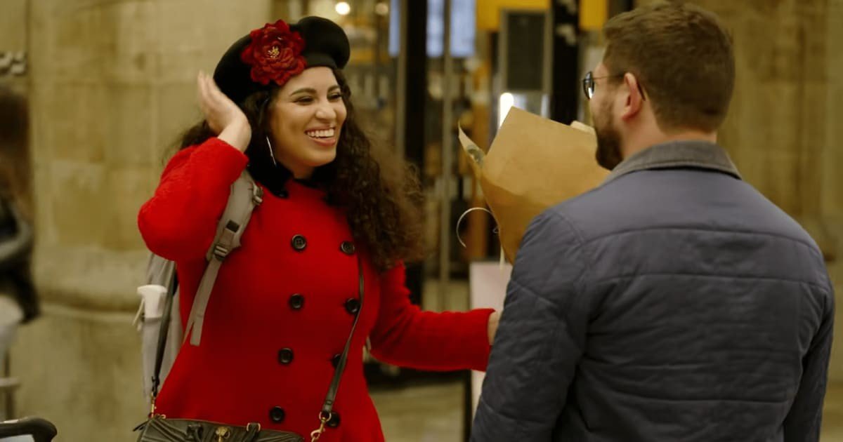 Zuri Soto arriving in France smiling in a red coat and beret