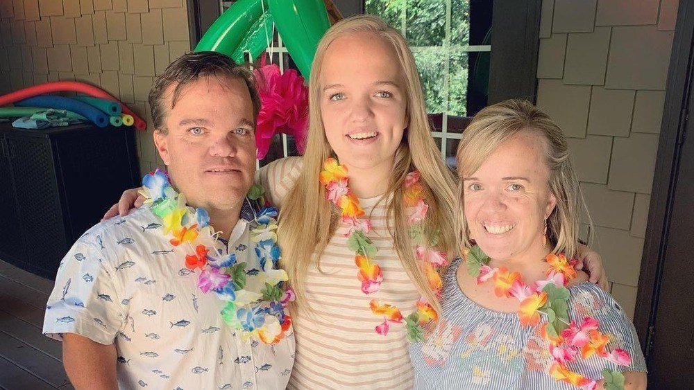 Amber, Trent and Liz Johnston smiling with flower leis