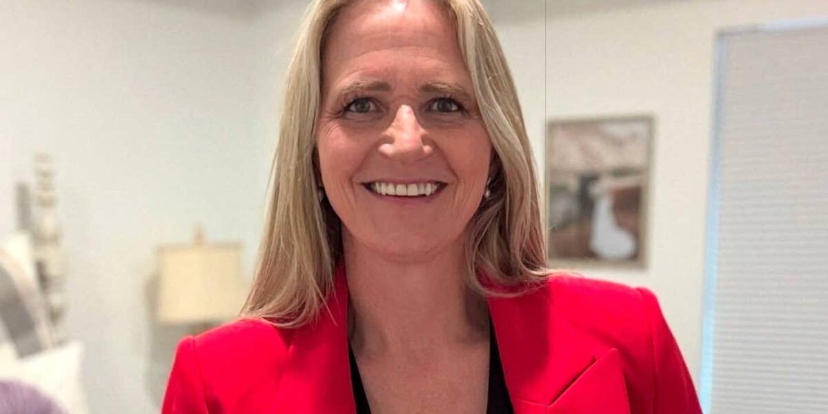 Christine Brown smiling in red blazer