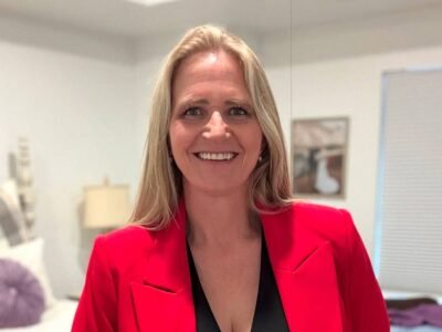 Christine Brown smiling in red blazer