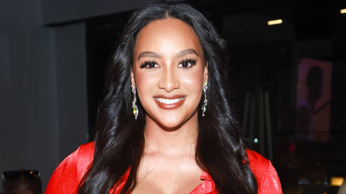 Chantel Everett smiling in a red dress with sparkling earrings