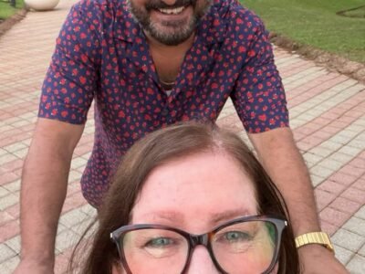 Jenny Slatten smiling in her wheelchair with Sumit during her Goa vacation