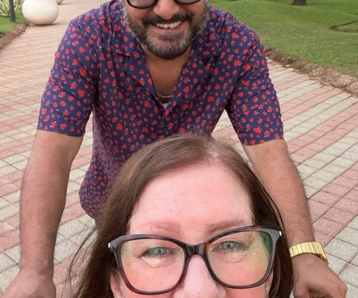 Jenny Slatten smiling in her wheelchair with Sumit during her Goa vacation