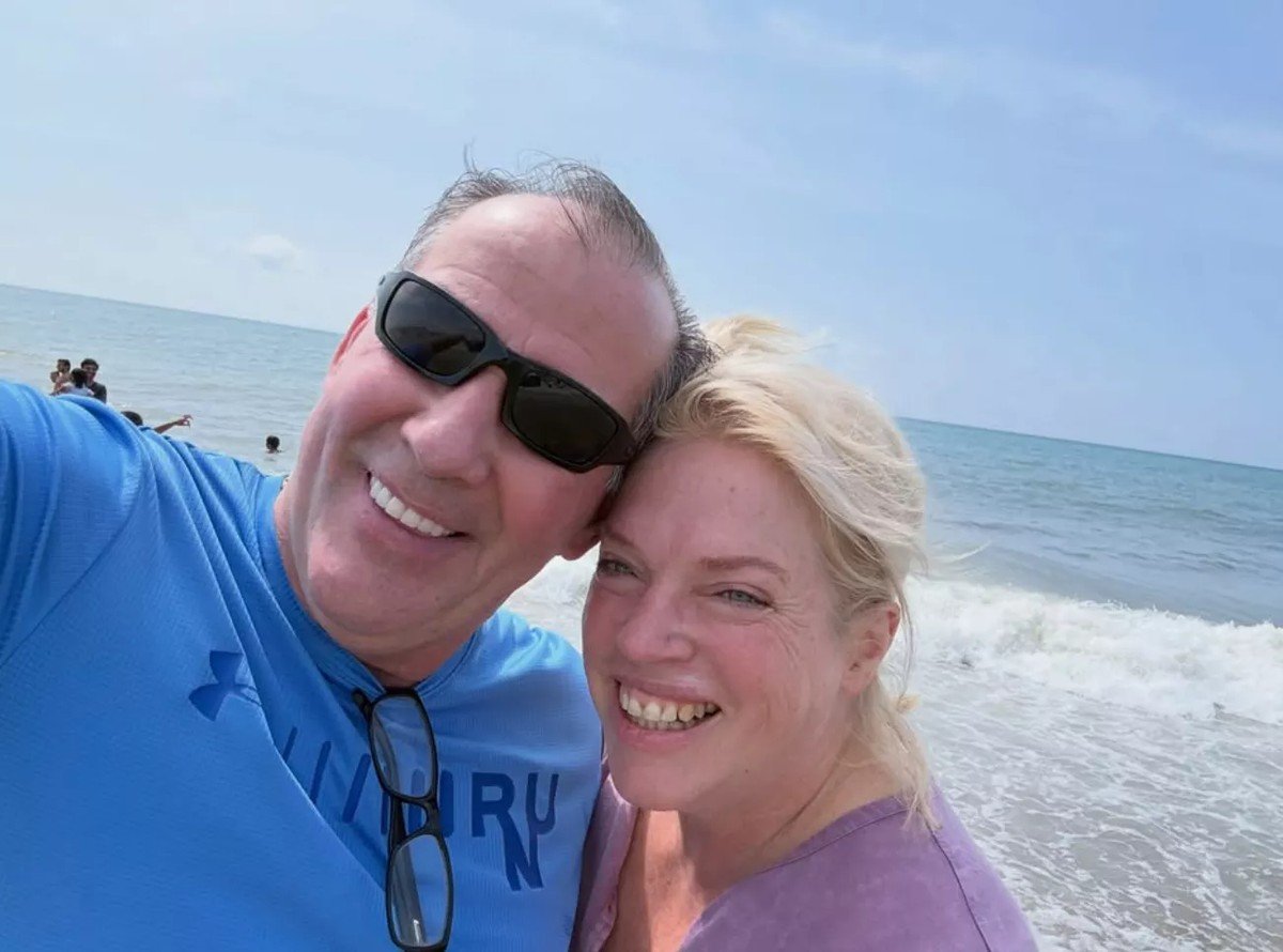 Janelle Brown and Pete smiling together at the beach