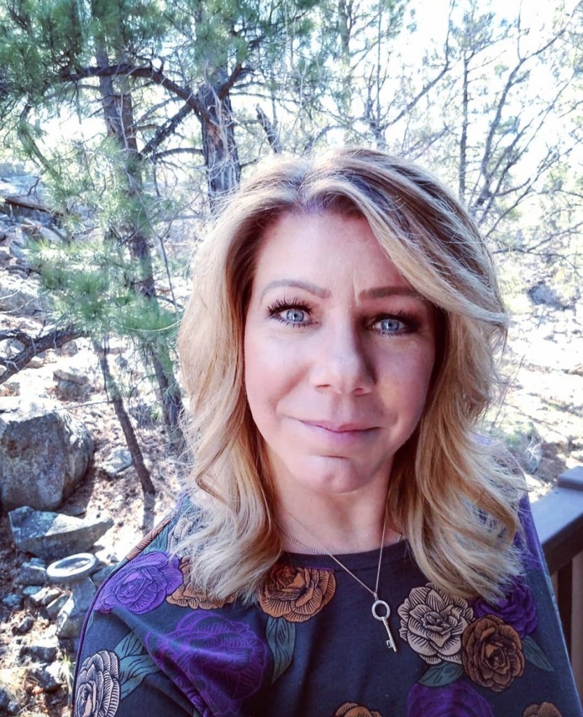 Meri Brown smiling in a casual outdoor selfie
