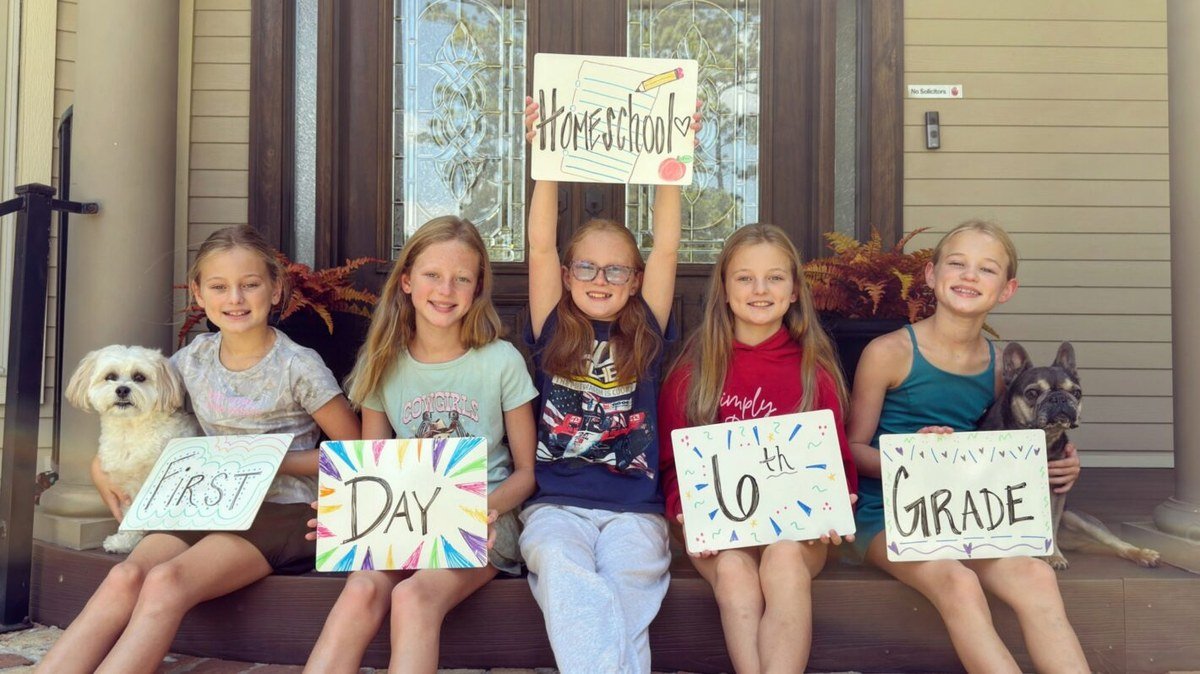 Busby quintuplets holding First Day of 6th Grade Homeschool signs