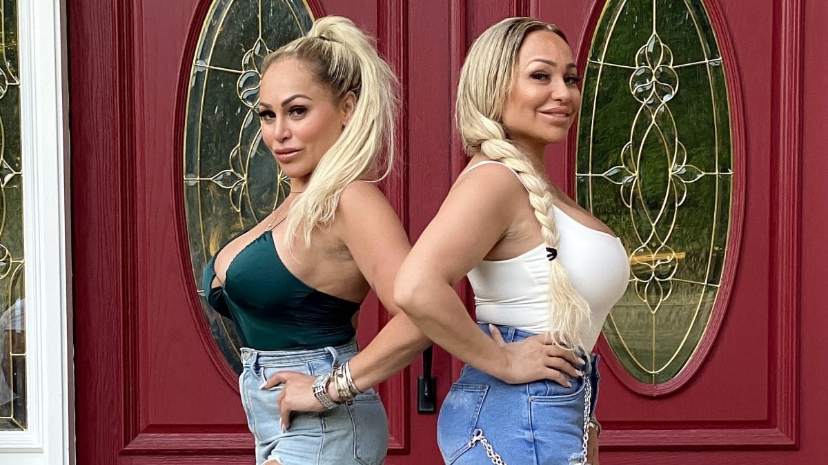 Darcey and Stacey Silva posing back to back together