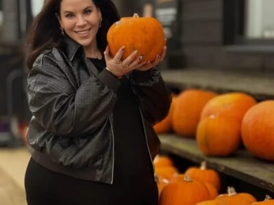 Whitney Way Thore smiling at a pumpkin patch in autumn