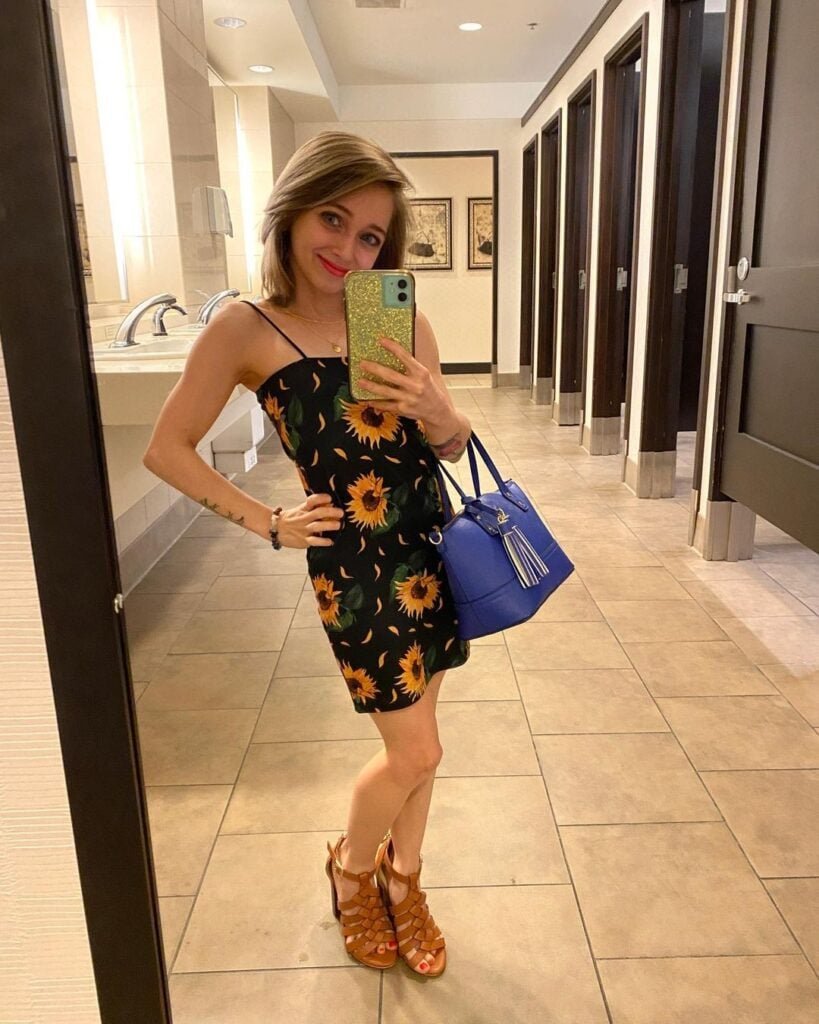 Shauna Rae taking a mirror selfie in a sunflower dress