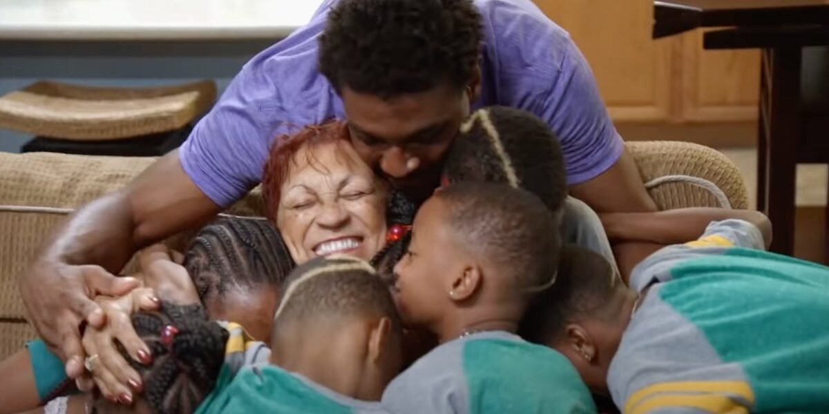 GG Derrico laughing while hugging Deon Derrico and her grandchildren
