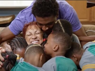 GG Derrico laughing while hugging Deon Derrico and her grandchildren