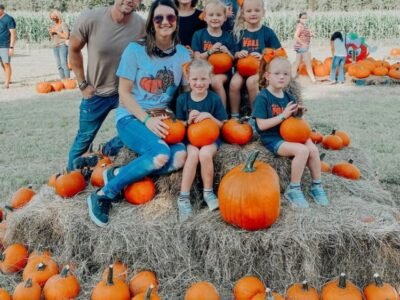 Adam and Danielle Busby with Blayke and the five quints at a pumpkin patch holding pumpkins