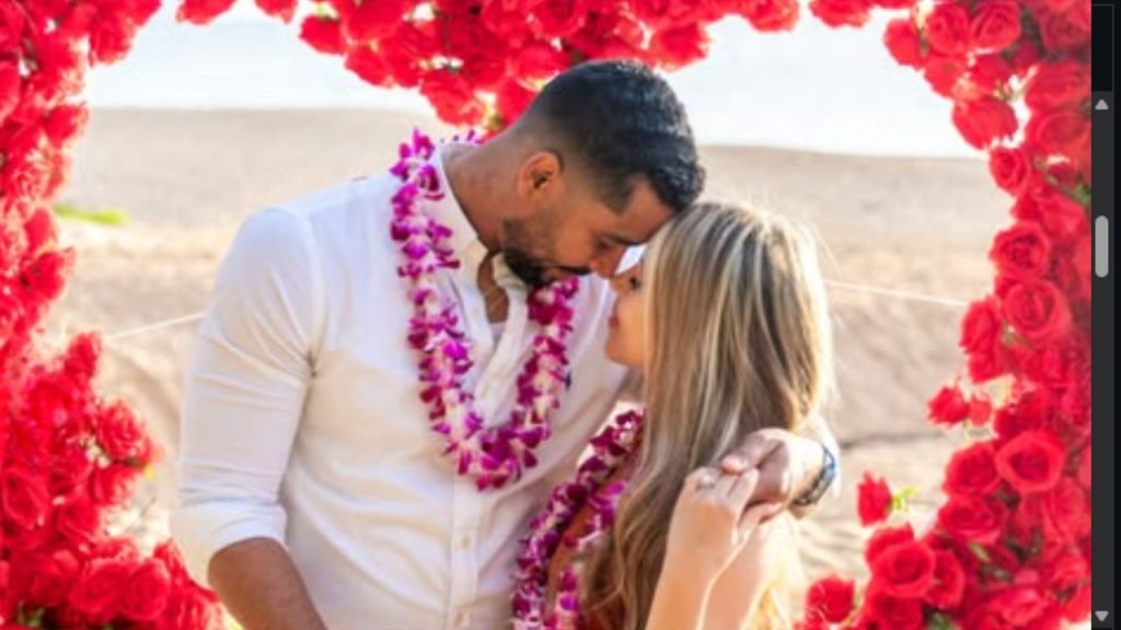 Pedro Jimeno and Valentina Malagon at their Hawaii beach proposal under a red rose arch