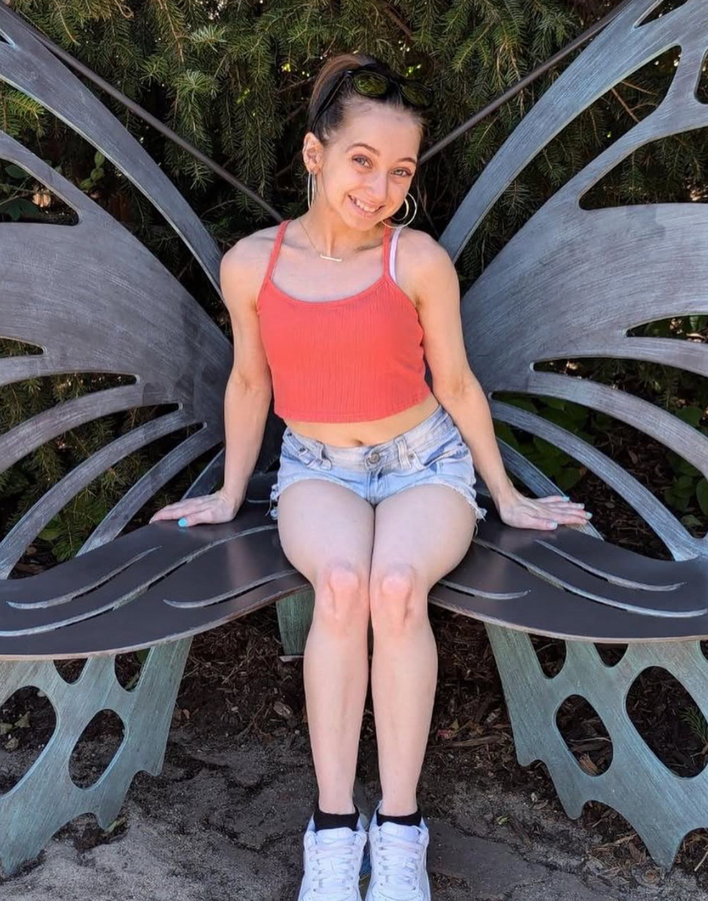 Shauna Rae smiling outdoors on a butterfly-shaped bench